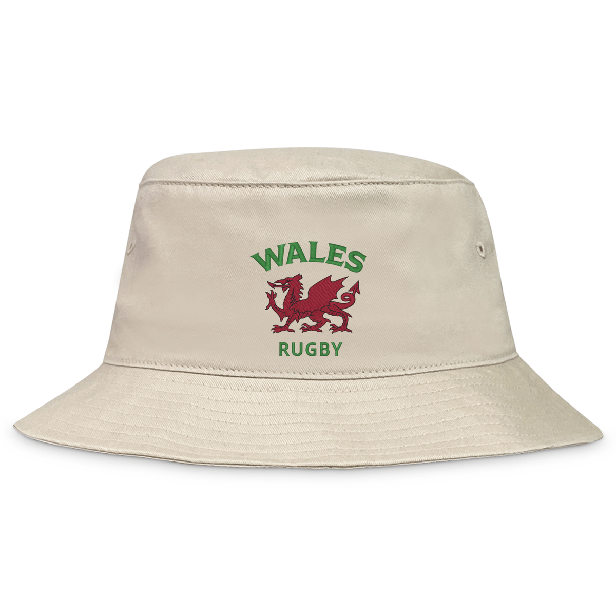 The EMB S&S Activewear Nations of Rugby Wales Rugby Crusher Bucket Hat features beige cotton twill with a red dragon and green "WALES RUGBY" text—perfect for fans showing their Welsh rugby pride.