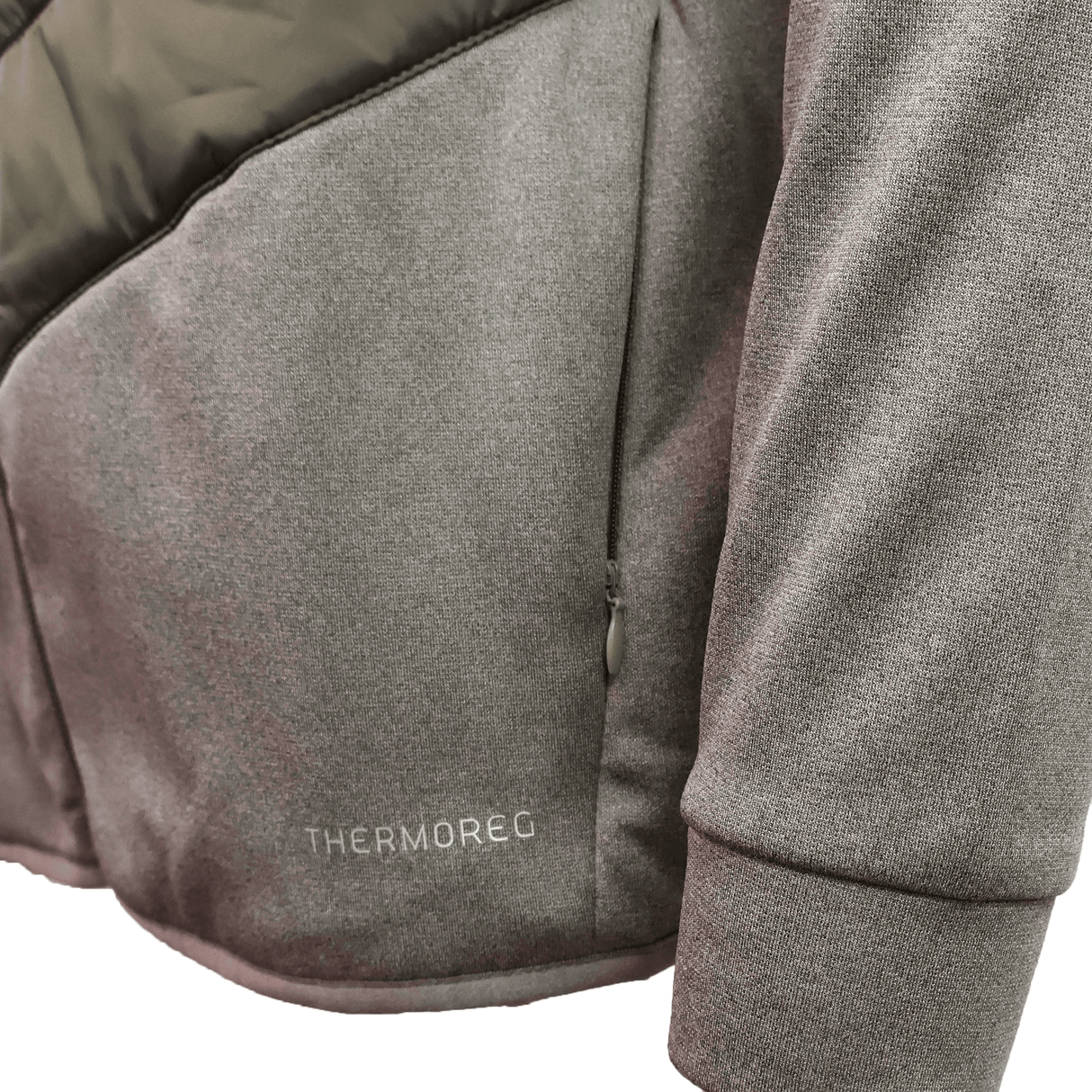 Close-up of a gray Canterbury Ireland 25/26 Hybrid Padded Jacket sleeve and side pocket, featuring "THERMOREG" near the hem to showcase its ThermoReg heat retention technology.