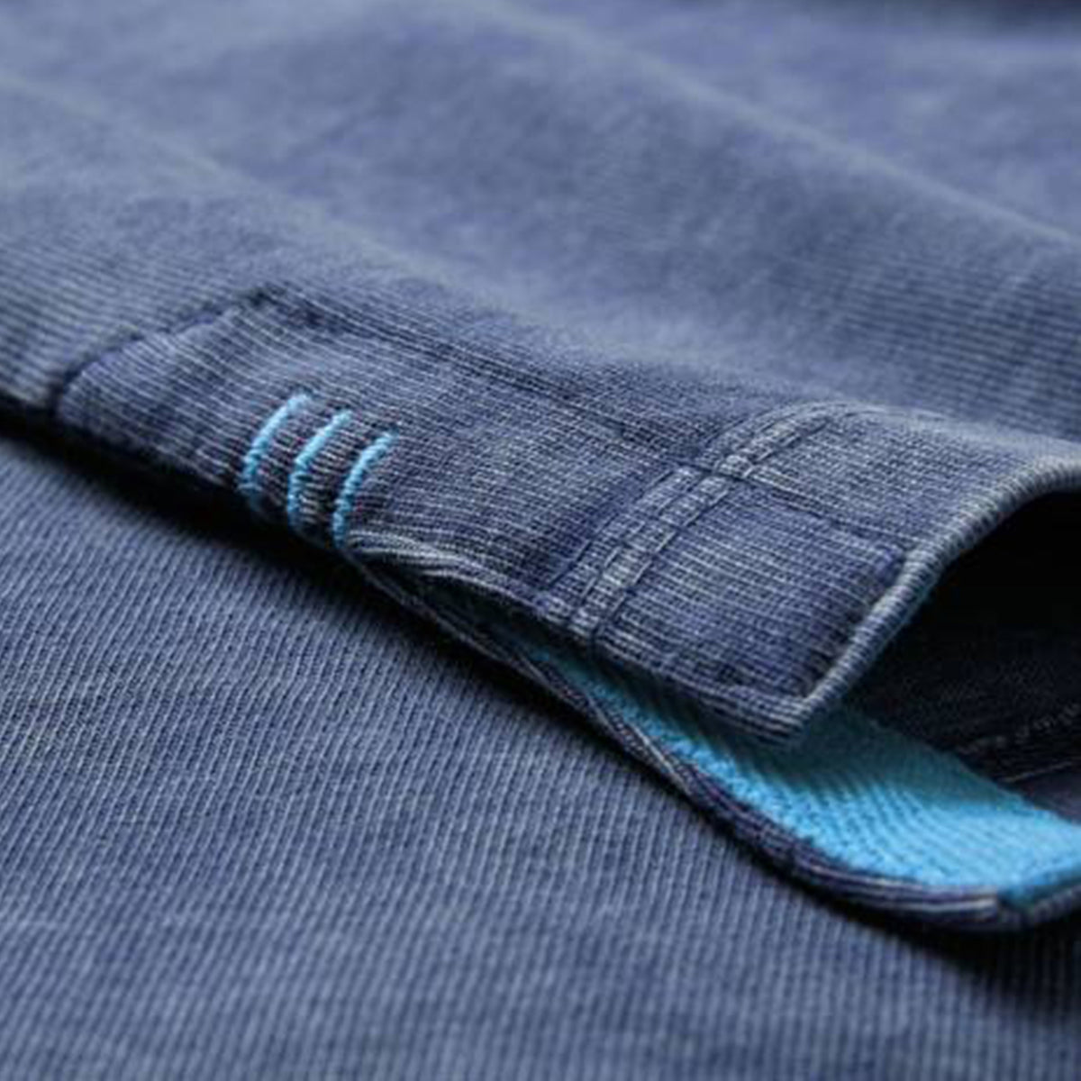 Close-up of the Ireland 26 Premium OS Washed T-shirt by Canterbury, featuring blue denim-style fabric with visible stitching and a subtle light blue lining inside the cuff, designed in an oversized fit inspired by classic Canterbury rugby shirts.
