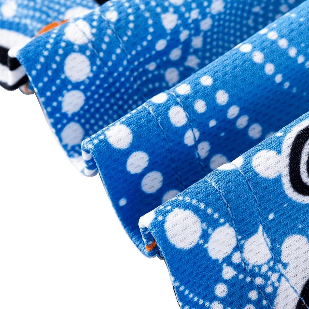 Close-up of three folded blue towels with white dotted patterns, echoing the design of the Sharks Indigenous NRL 25/26 Replica Jersey by Classic Sportswear, and a black letter partially visible on one towel.