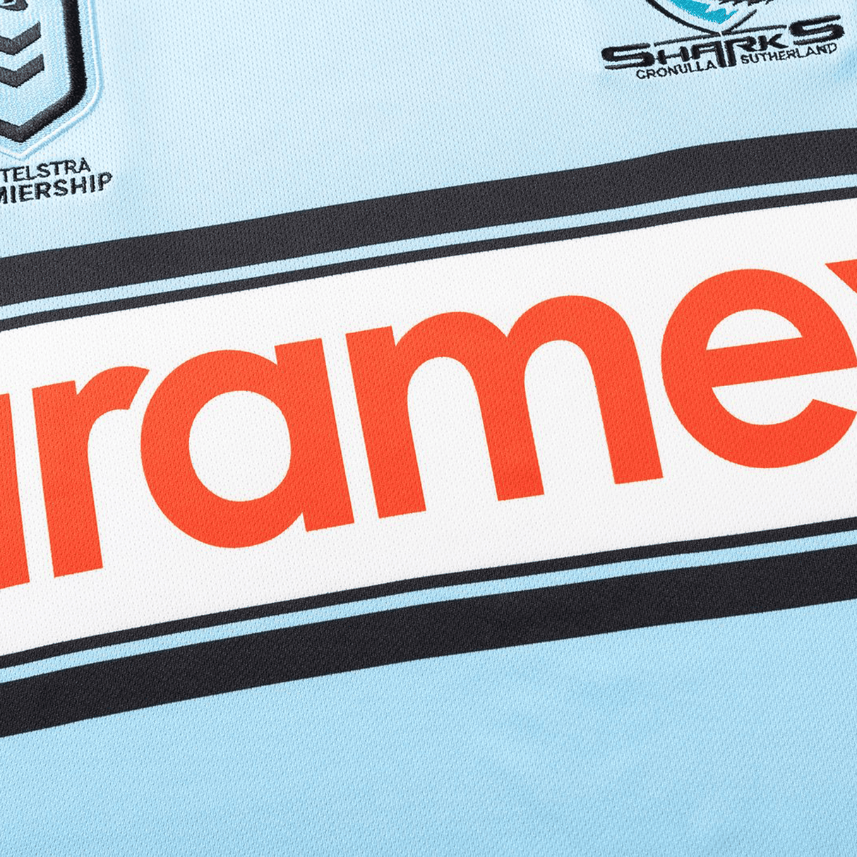 Close-up of the Sharks NRL 26/27 Replica Home Jersey by Classic Sportswear, with the team's and NRL logos plus a bold red sponsor name on a light blue background.