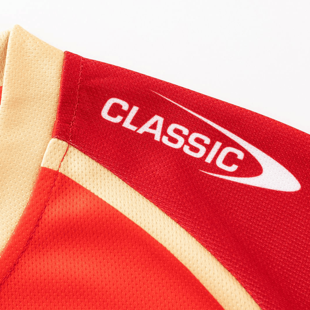 Close-up of the Dolphins NRL 26/27 Replica Home Jersey by Classic Sportswear in red and gold, showing "CLASSIC" branding and a swoosh graphic on the shoulder.