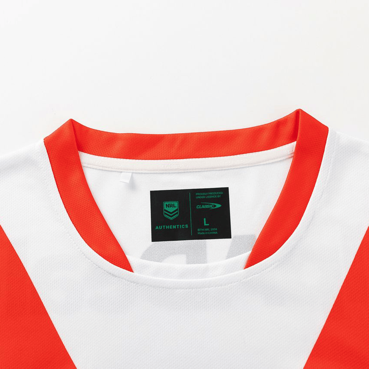 A close-up of the collar and tags on the Dragons NRL 26/27 Replica Home Jersey by Classic Sportswear, featuring red accents, the NRL Authentics logo, Classic Sportswear branding, and a size label.
