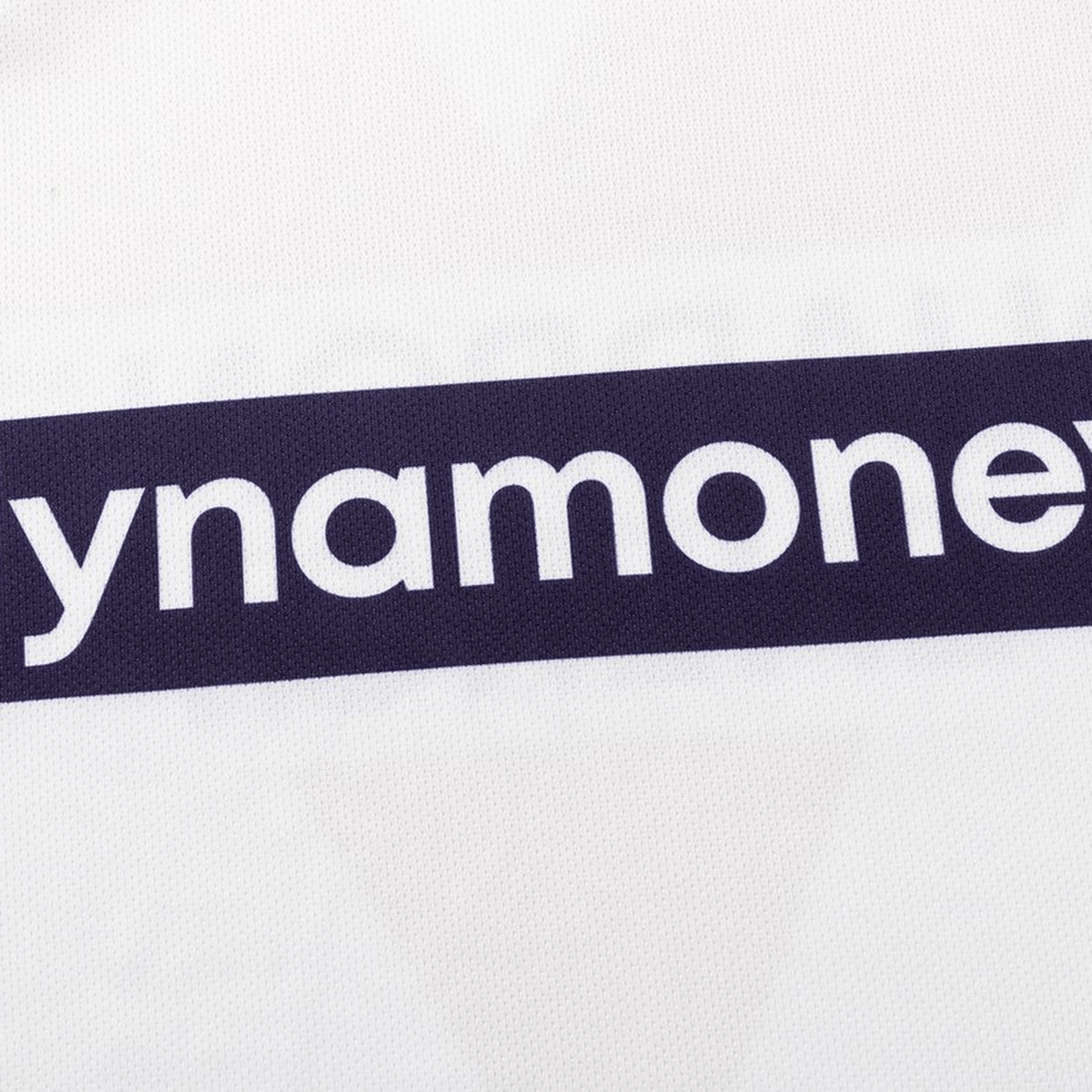 A close-up of white fabric with partial "ynamone" text in bold white letters on a dark stripe, from the Dragons NRL 26/27 Replica Home Jersey by Classic Sportswear.