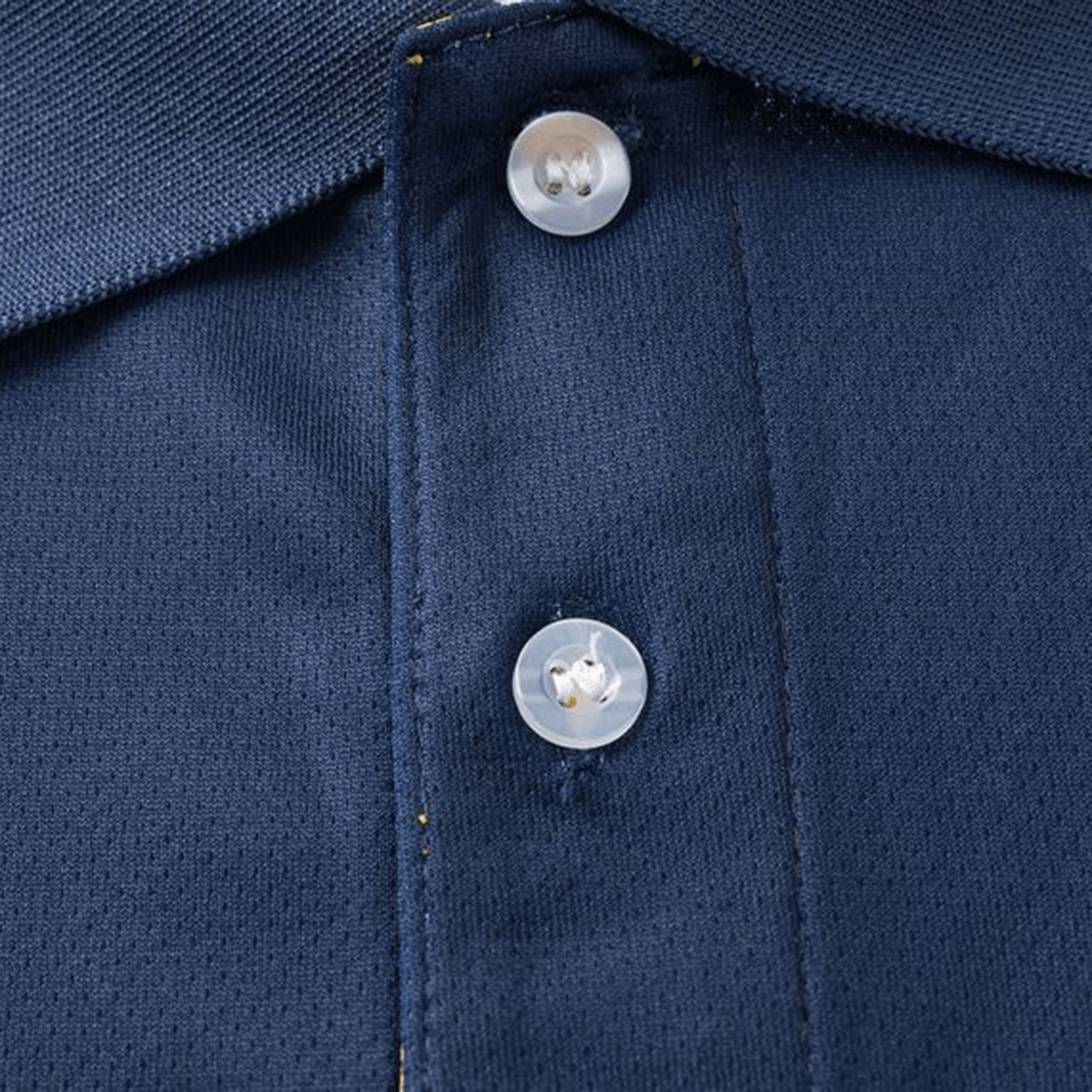 Close-up of the Highlanders Super Rugby Team Polo 25/26 by Classic Sportswear, showcasing a navy blue design with two white buttons and yellow stitching. Crafted from moisture-wicking fabric, it's ideal for fans seeking comfort.