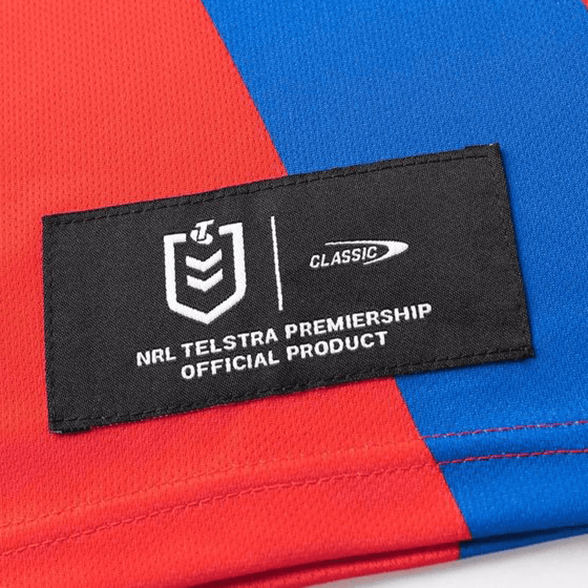 Close-up of the Knights NRL 25/26 Replica Home Jersey by Classic Sportswear, showcasing a red and blue design with sublimated graphics and an NRL Telstra Premiership official product label.