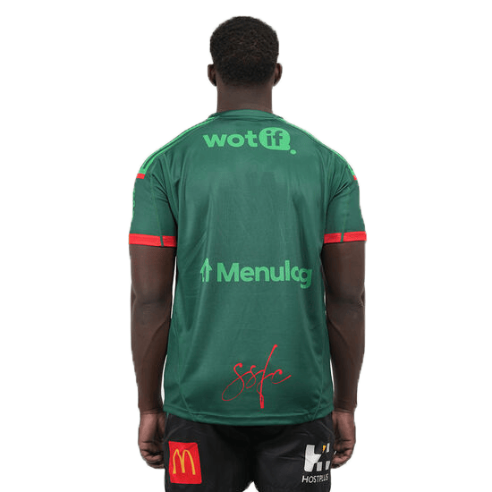 A person wearing a green Rabbitohs NRL 25/26 Special Edition Captains Run Jersey by Classic Sportswear, showcases logos for "wotif," "Menulog," and "Sofc." Paired with black shorts featuring matching logos, it completes the classic sportswear look.