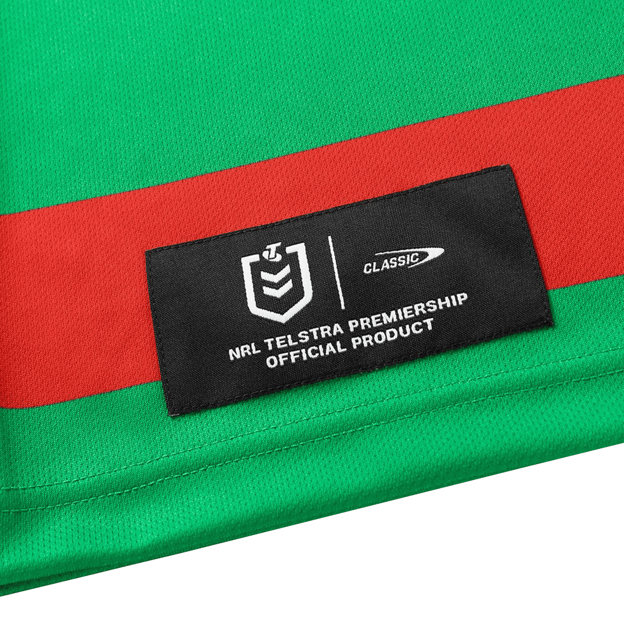 A close-up of the Rabbitohs NRL 26/27 Replica Home Jersey by Classic Sportswear, featuring green and red panels and a black label indicating it’s an official NRL Telstra Premiership product.