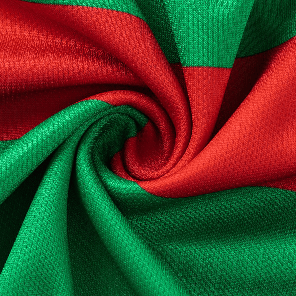 A close-up of fabric with red and green stripes, twisted into a spiral, reminiscent of the Rabbitohs NRL 26/27 Replica Home Jersey by Classic Sportswear.