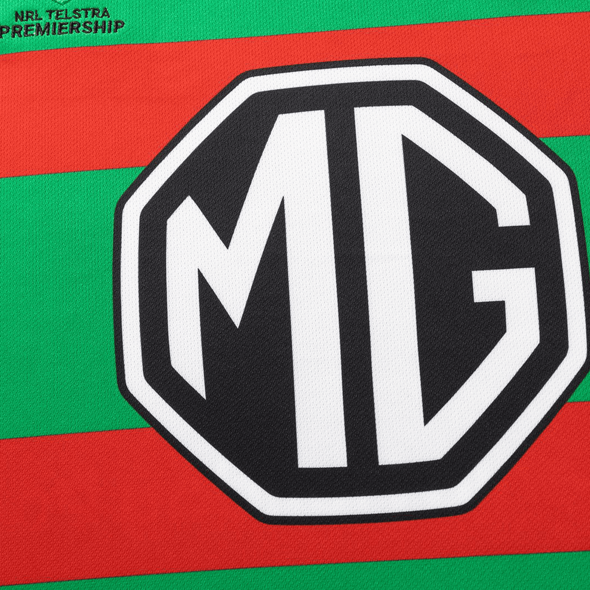 Close-up of the green and red striped Rabbitohs NRL 26/27 Replica Home Jersey by Classic Sportswear, featuring a bold black and white MG logo and a small "NRL Telstra Premiership" text in the corner.