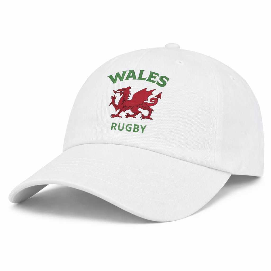 The EMB S&S Activewear Nations of Rugby Wales Dad Cap is a white cotton cap featuring a red Welsh dragon and green "WALES RUGBY" embroidery—a classic choice for rugby fans.