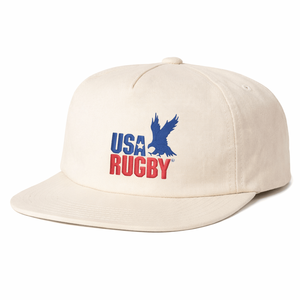 The EMB Weld USA Rugby Throwback Brushed Cotton Cap features “USA RUGBY” in blue and red with a blue eagle graphic. This beige limited edition hat is perfect for true fans.