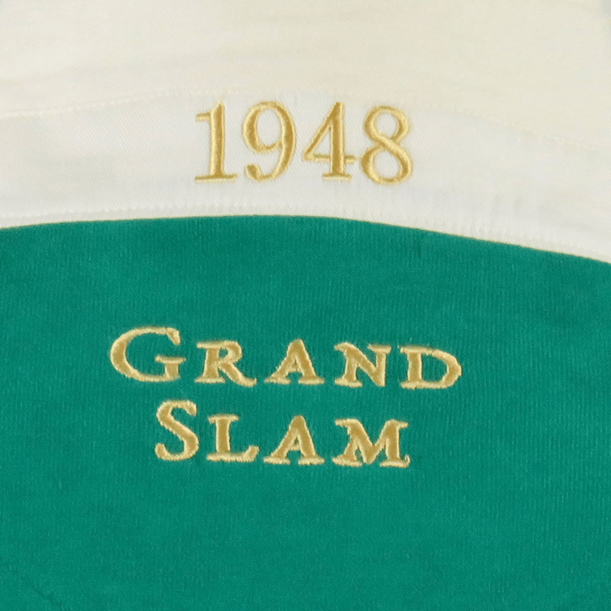 The Ellis Rugby Ireland 1948 Grand Slam Classic Rugby Shirt, by Ellis Rugby, showcases green and white fabric with bold yellow text reading "1948" at the top and "Grand Slam" at the bottom, celebrating Ireland's legendary 1948 rugby victory.