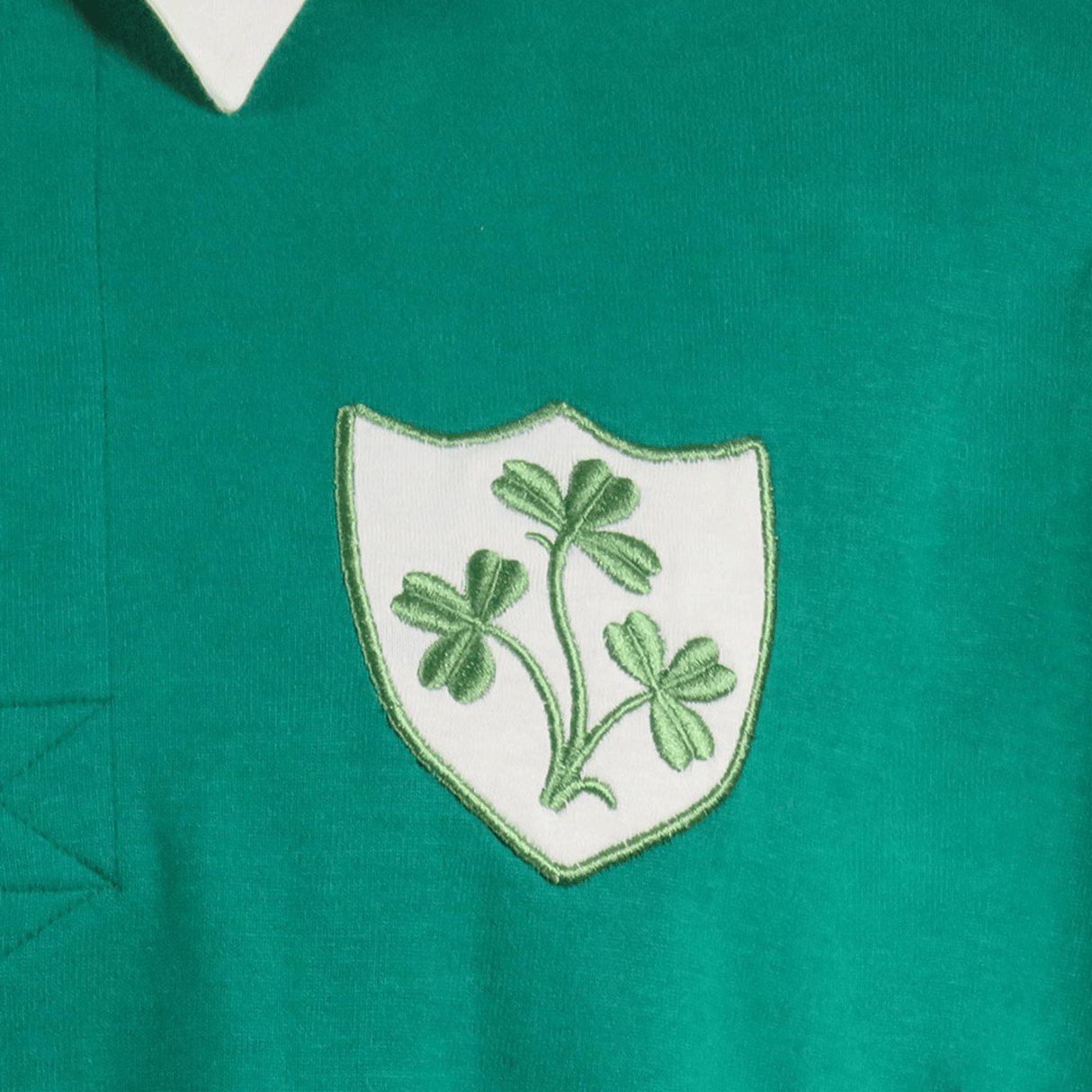 The Ellis Rugby Ireland 1948 Grand Slam Classic Rugby Shirt is a vintage piece featuring a green shirt with a white shield emblem and a green shamrock design, echoing the iconic era.