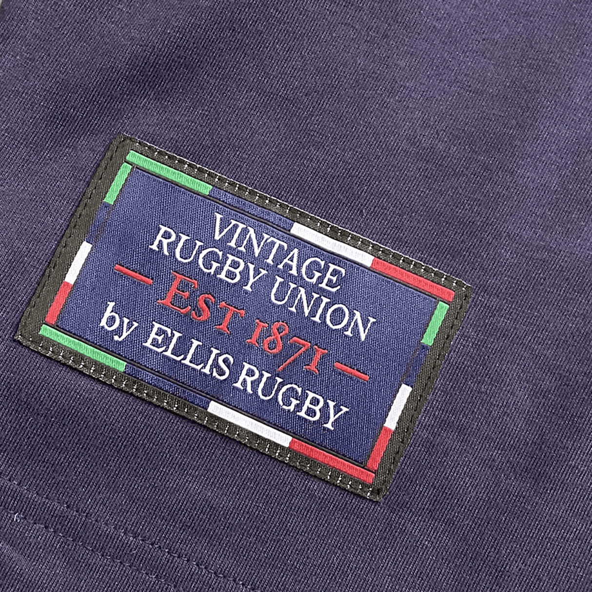 The Ellis Rugby Scotland Rugby 1990 Grand Slam Shirt features a patch with "Vintage Rugby Union EST 1871 by Ellis Rugby" on dark fabric, red, green, and white borders capturing the essence of the iconic victory.