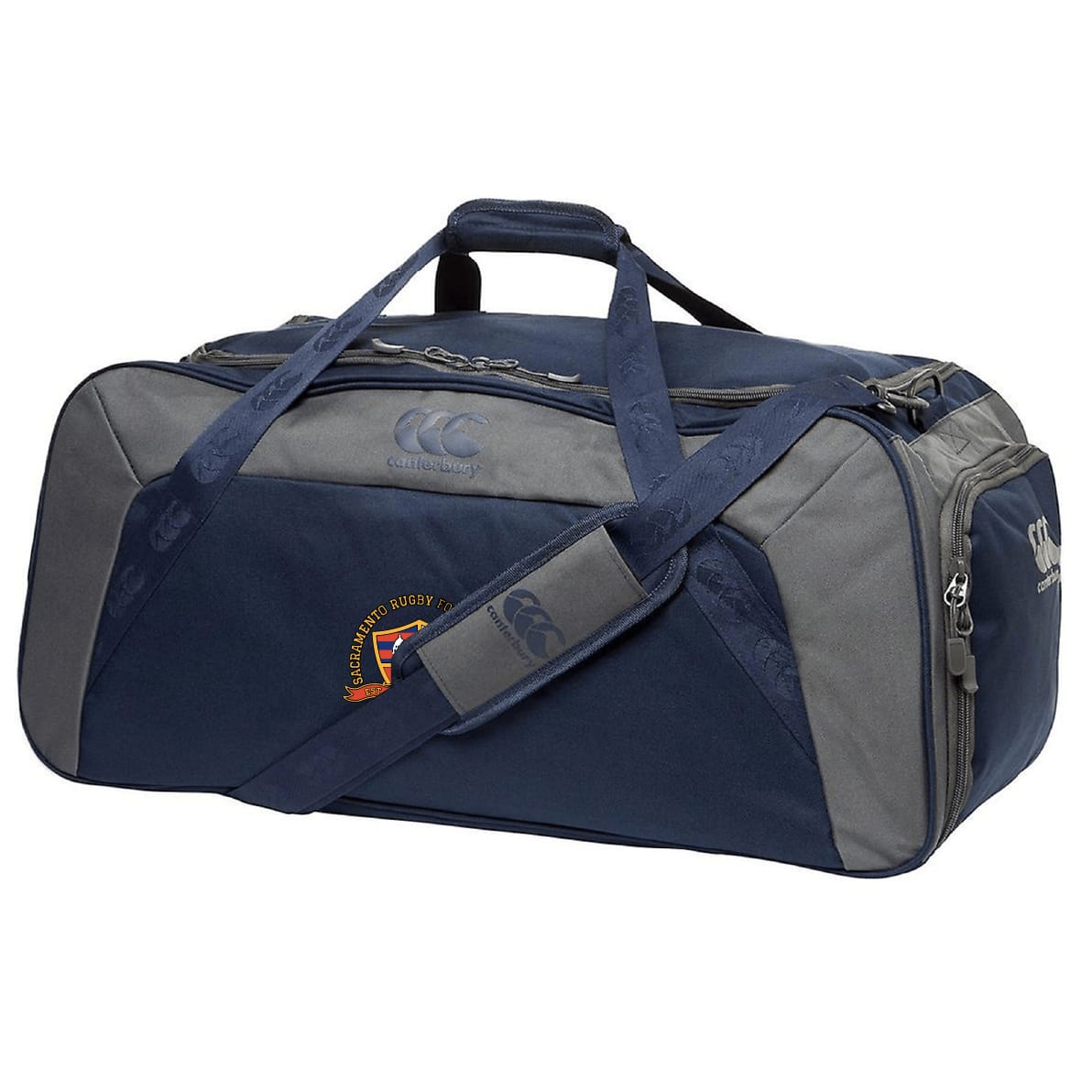 The EMB Canterbury Sacramento Rugby Football Club Holdall Duffle Bag is a navy blue and gray duffle with top handles, a shoulder strap, zippered main compartment, and a small embroidered logo on the side.