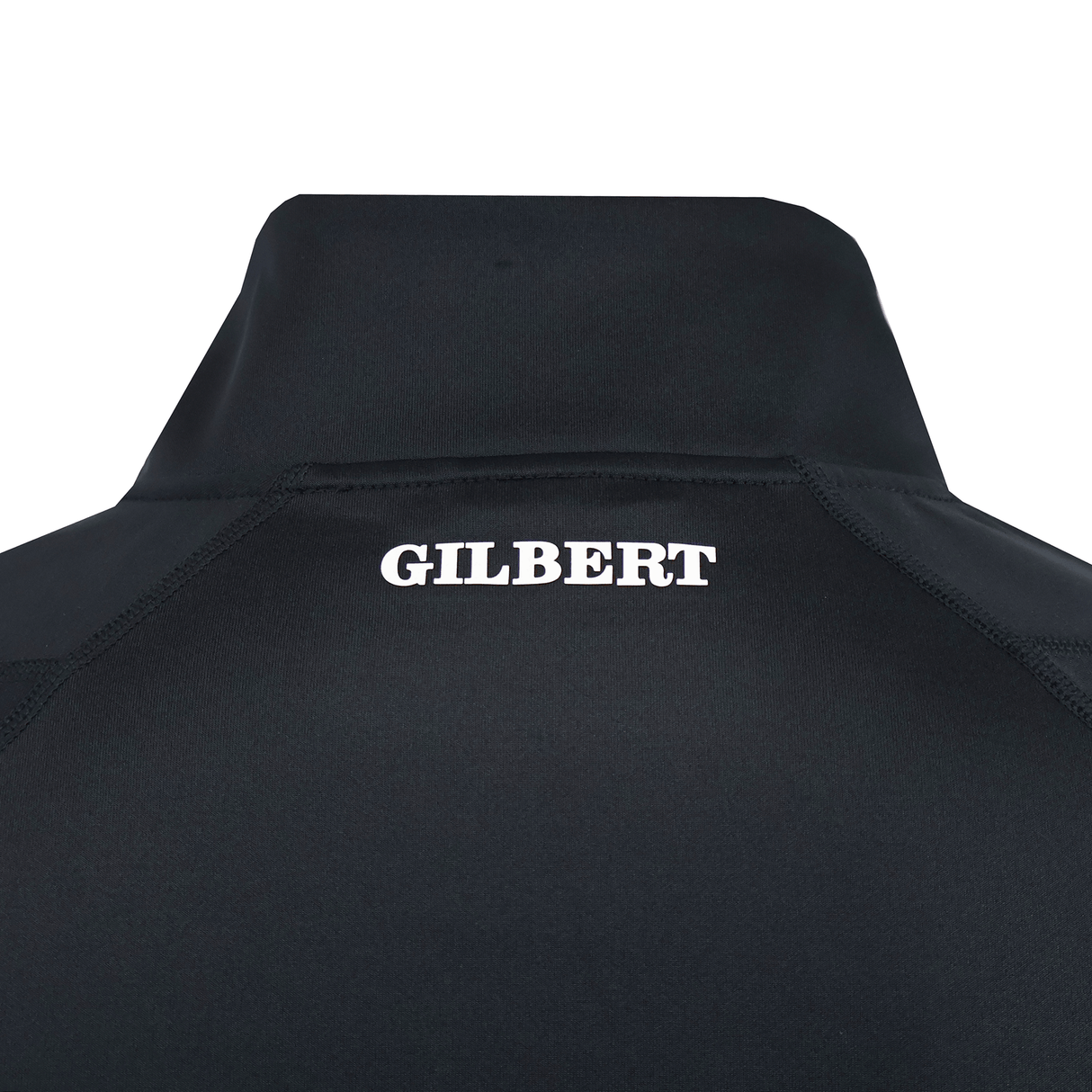 Close-up of the back of the black Gilbert GTS 1/4 Zip Poly Pullover, with "GILBERT" printed in white capital letters near the collar.
