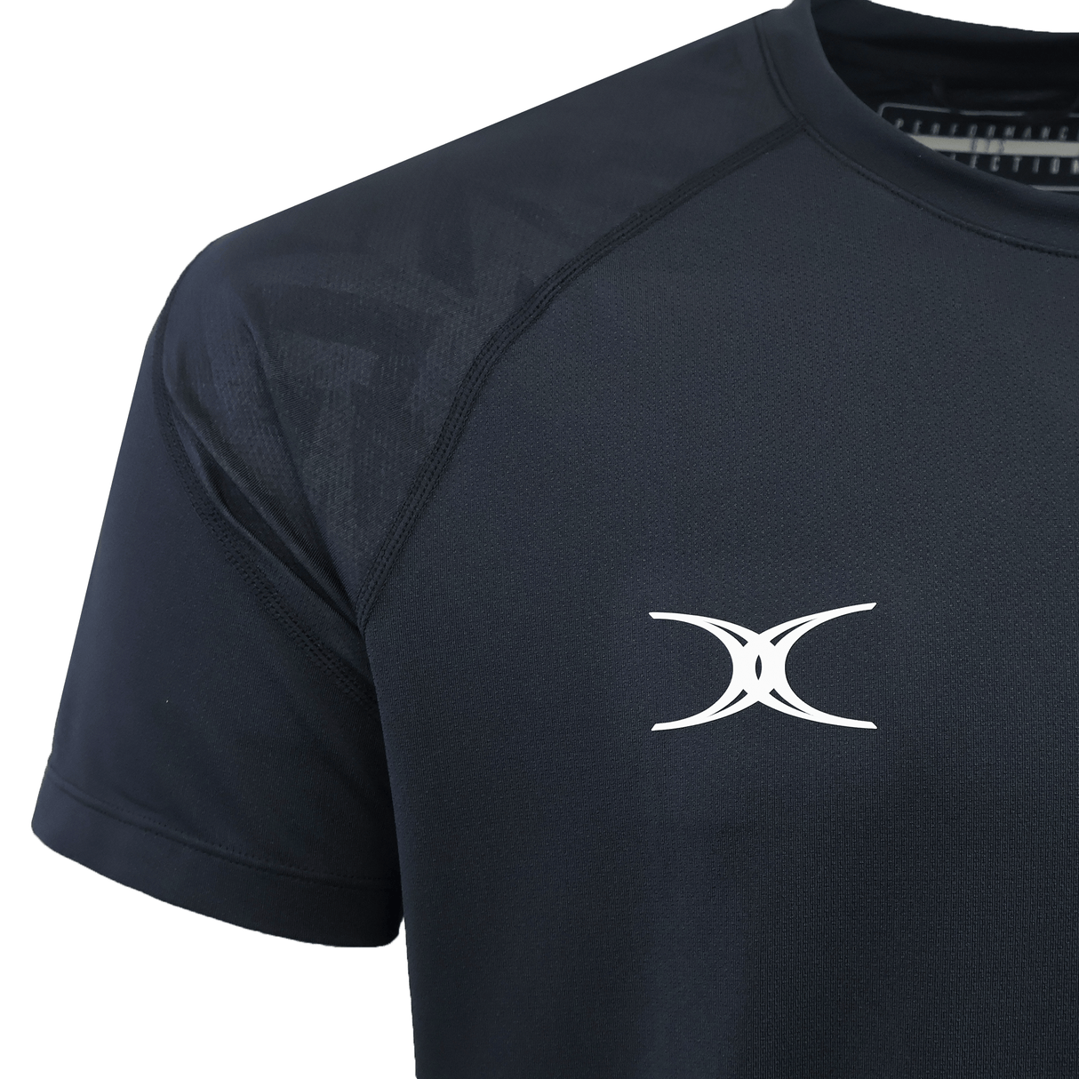 Close-up of the black Gilbert GTS Training Tee by Gilbert, featuring a white abstract logo on the left chest and moisture wicking fabric.