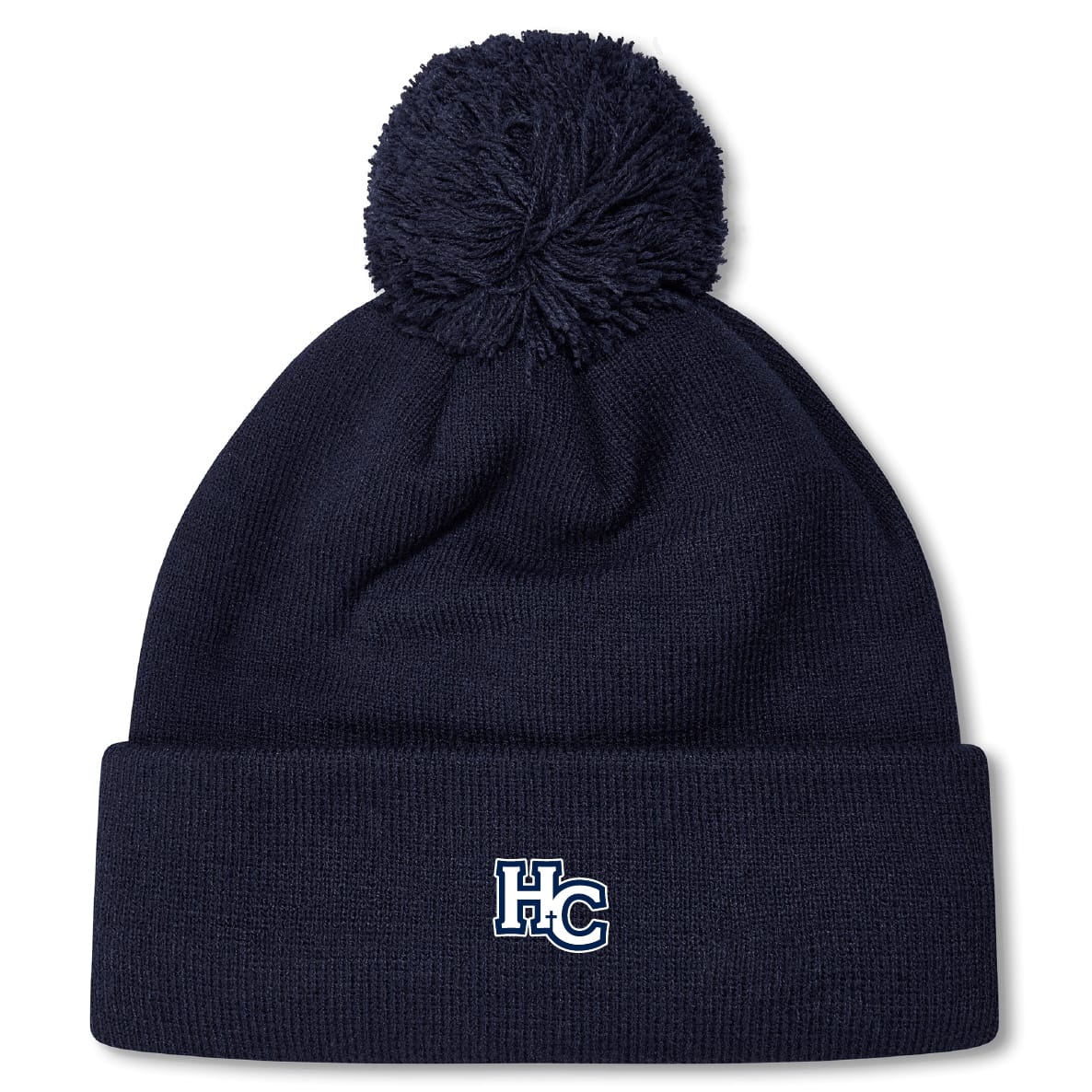 The Holy Cross Pom Pom Beanie by EMB Canterbury features a navy blue knit design, playful pom-pom, and an “HC” logo embroidered on the front cuff—a classic rugby bobble hat look.