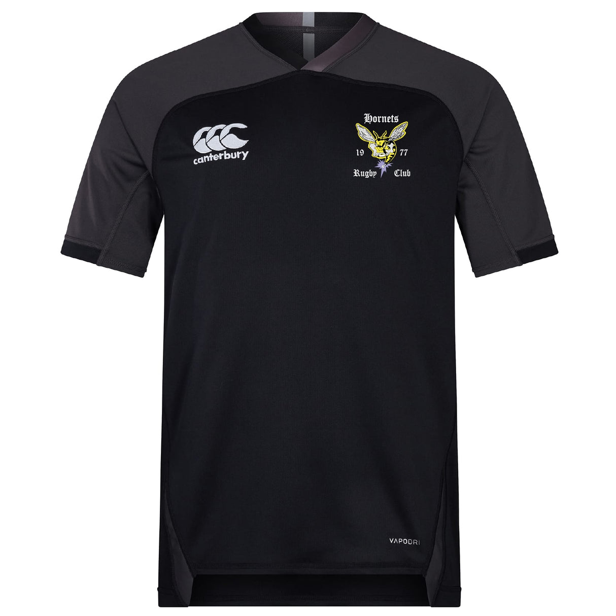The EMB Canterbury Hornets Rugby Club Vapodri Evader Jersey is a black short-sleeved top with moisture-wicking tech, featuring the Canterbury logo and a yellow hornet crest reading “Hornets Rugby Club 1977” on the chest.