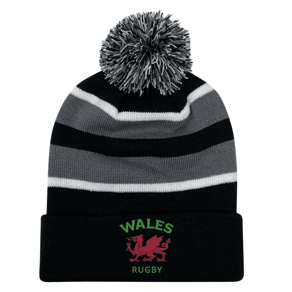 The EMB Augusta Nations of Rugby Wales Hooped Knit Fold Over Pom-Pom Beanie features black, grey, and white stripes, "WALES RUGBY" text, a pom-pom top, and an embroidered red dragon logo on the front.
