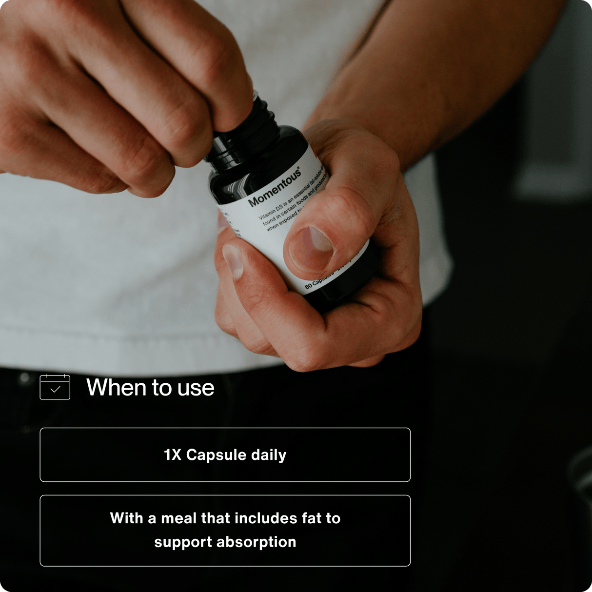 A person opens a bottle of Momentous Vitamin D3 5000 IU by Momentous, labeled with instructions to take one capsule daily with a fat-containing meal for better absorption to support immune function and bone strength.