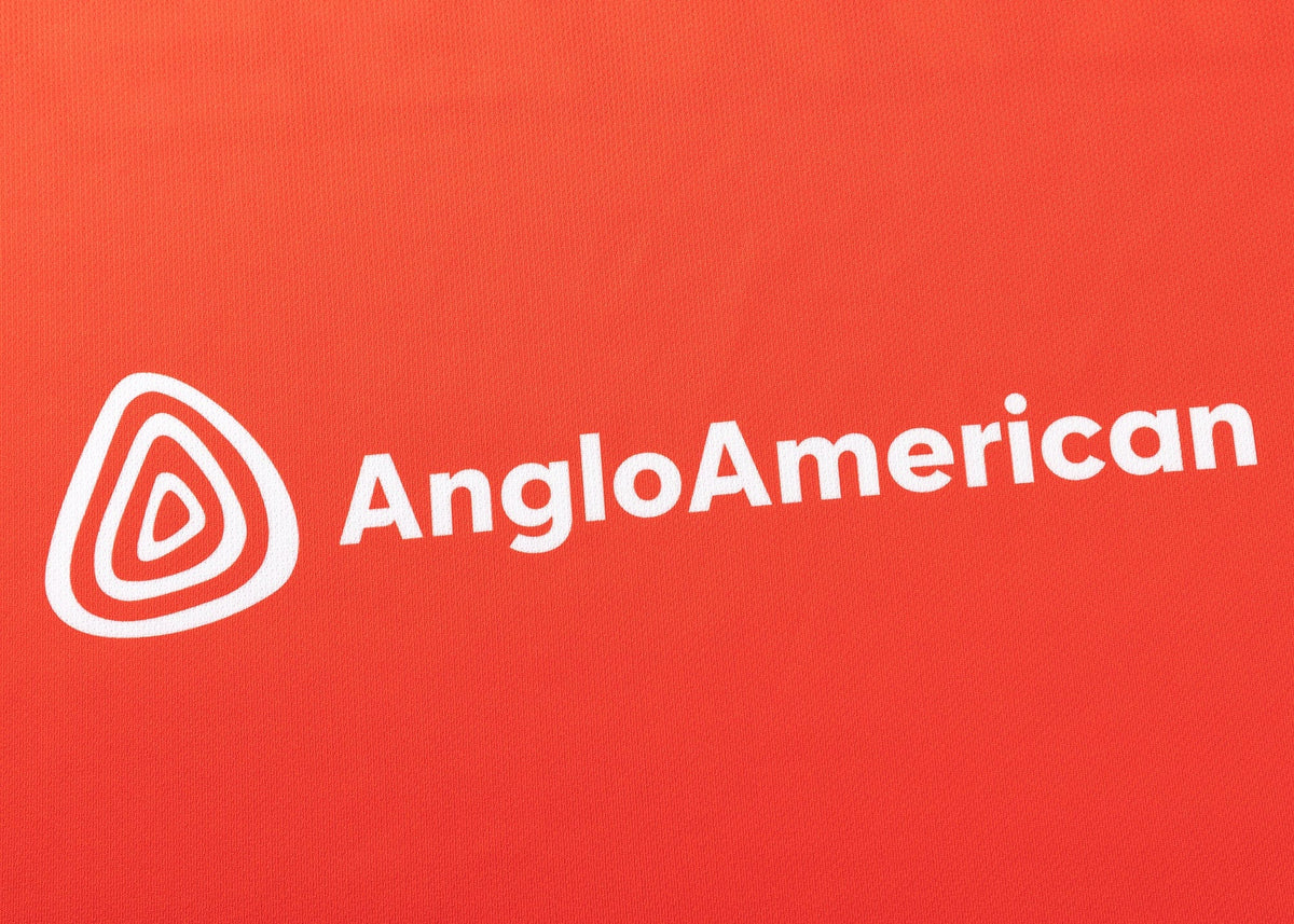 The image showcases the Anglo American logo in white on a red background, similar to the Dolphins NRL 25/26 Replica Home Jersey by Classic Sportswear.