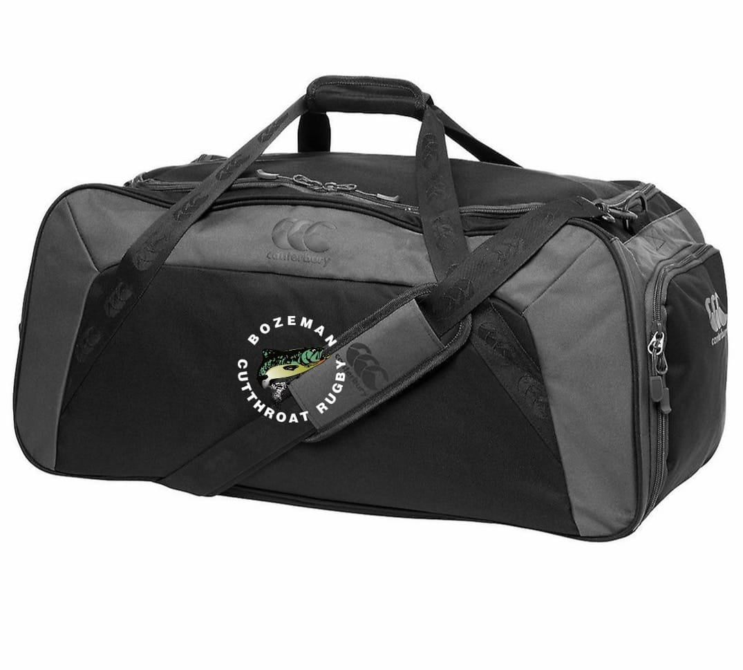 The EMB Canterbury Bozeman Cutthroats Rugby Holdall Duffle Bag is black and gray with handles, a shoulder strap, water-repellent finish, and the "Bozeman Cutthroat Rugby" logo on the side.