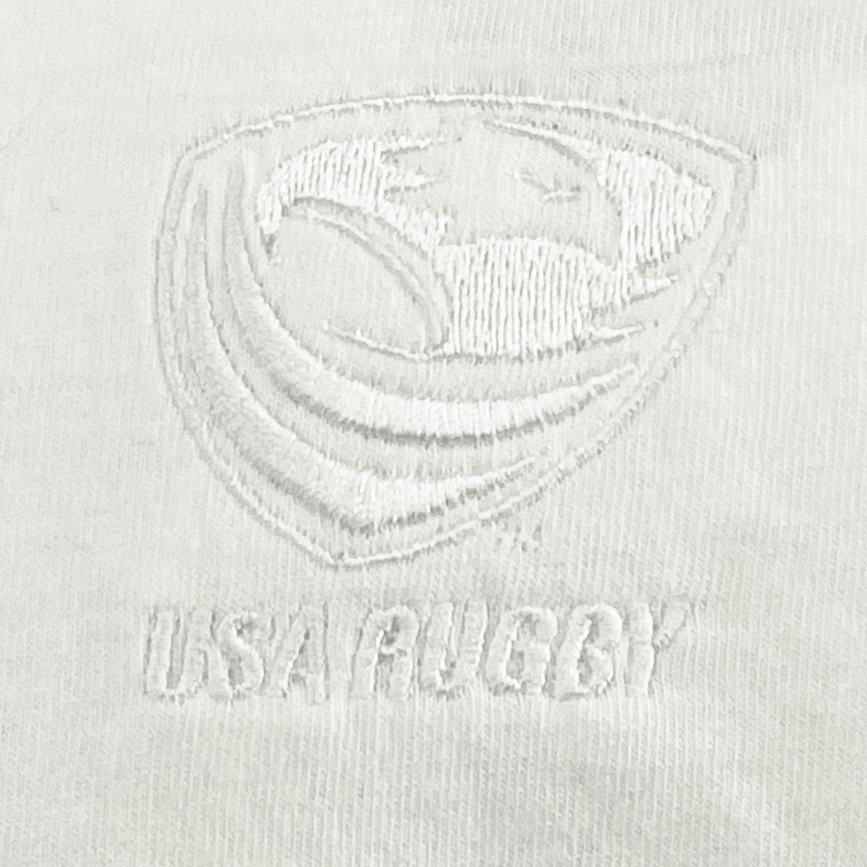The EMB S&S Activewear USA Rugby Elevated Tonal Comfort Tee features a white embroidered eagle logo above "USA RUGBY" on white fabric—a sleek, subtle design perfect for fans seeking stylish comfort.