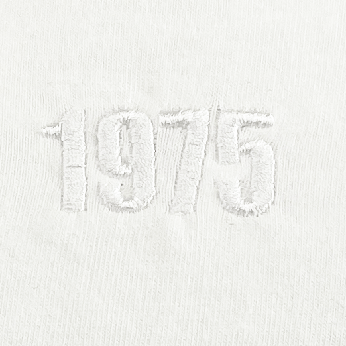 The EMB S&S Activewear USA Rugby Elevated Throwback Tonal Comfort Tee features white fabric with "1975" embroidered in a subtle tone at the center, offering a classic nod to vintage USA Rugby style.