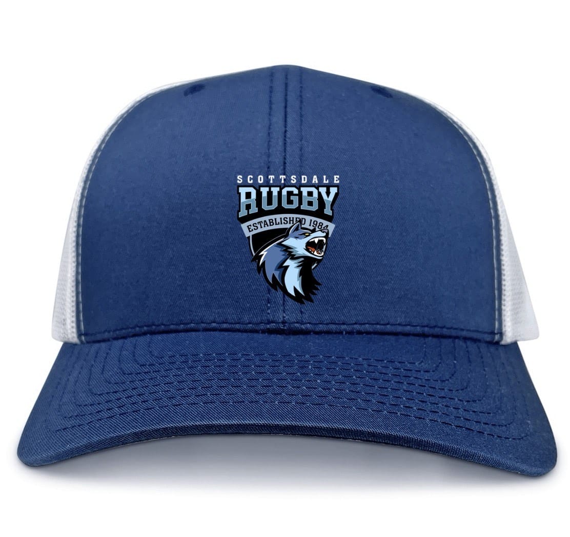 The Scottsdale Rugby Royal Retro Trucker Cap by EMB S&S Activewear features blue and white panels, an embroidered "Scottsdale Rugby" logo with a wolf and "Established 1986" on the front, plus a classic snapback closure.