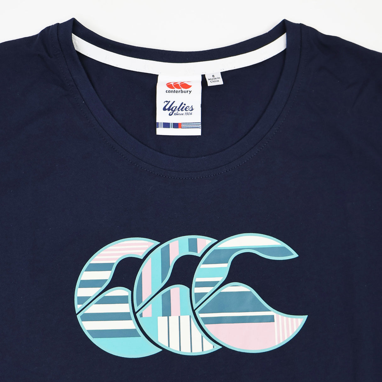 Introducing the Canterbury Women's Uglies Logo T-Shirt—a navy blue tee featuring a standout “CCC” logo in pastel blue, pink, and white across the chest. With a signature Canterbury Uglies tag at the neckline, this shirt brings sporty style and bold design together, making it a must-have for any fan of classic Canterbury rugby shirts or anyone looking to expand their women’s rugby t-shirt collection.