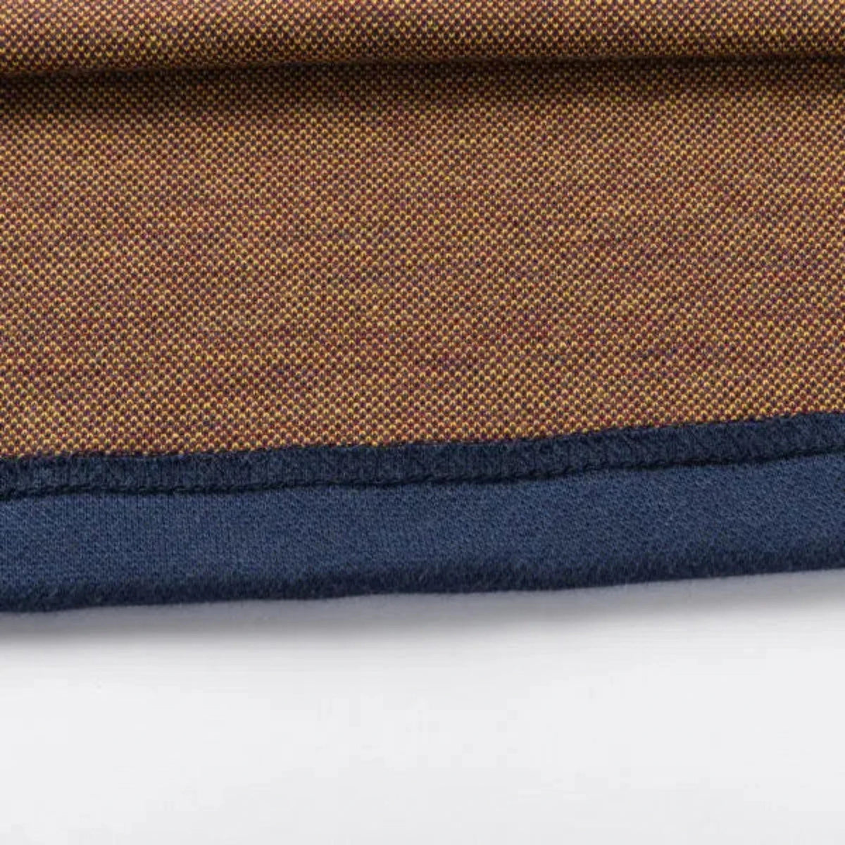 A close-up showcases the textured brown pattern and contrasting dark blue edge of the Limited Edition Highlanders Super Rugby 25/26 Retro Jersey by Classic Sportswear, reminiscent of classic sportswear, set against a white surface.