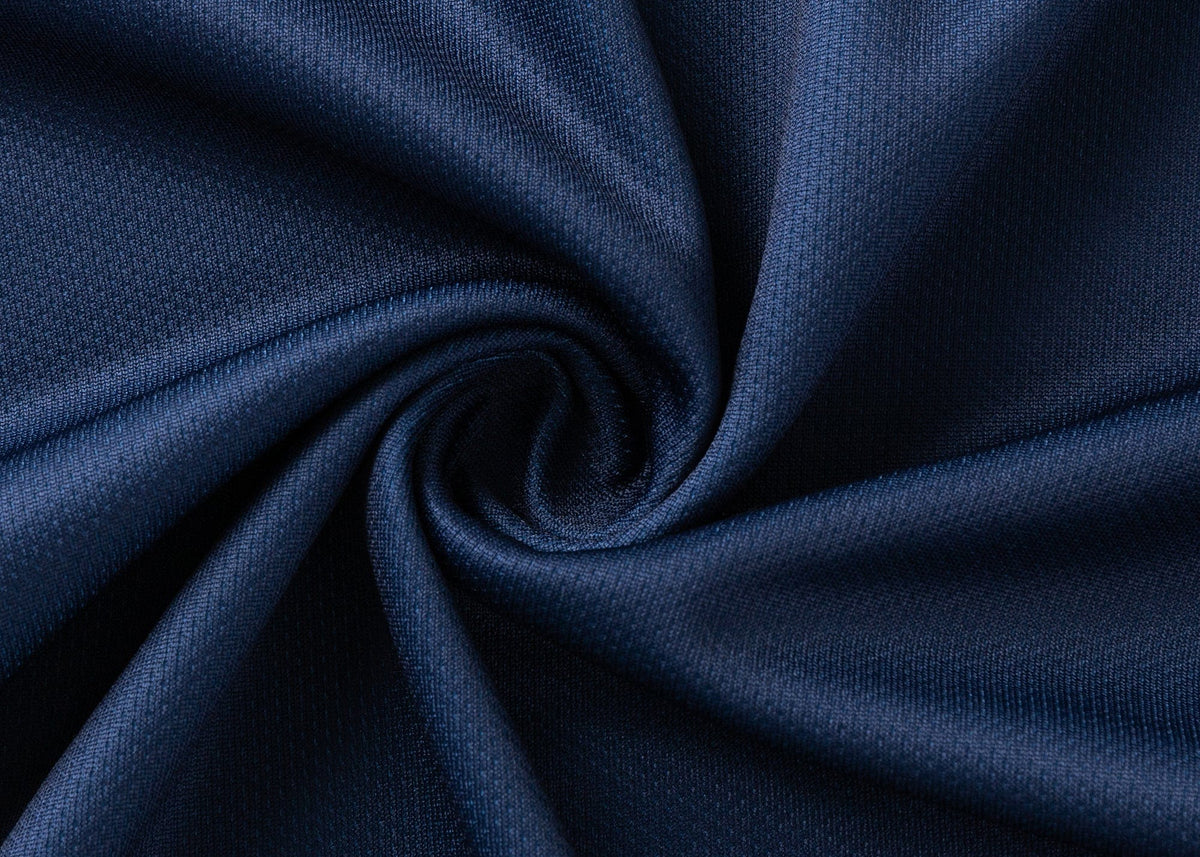 A close-up of dark blue, textured fabric, twisted at the center to form a spiral pattern, resembles the moisture-wicking Highlanders Super Rugby 25/26 Replica Home Jersey by Classic Sportswear.