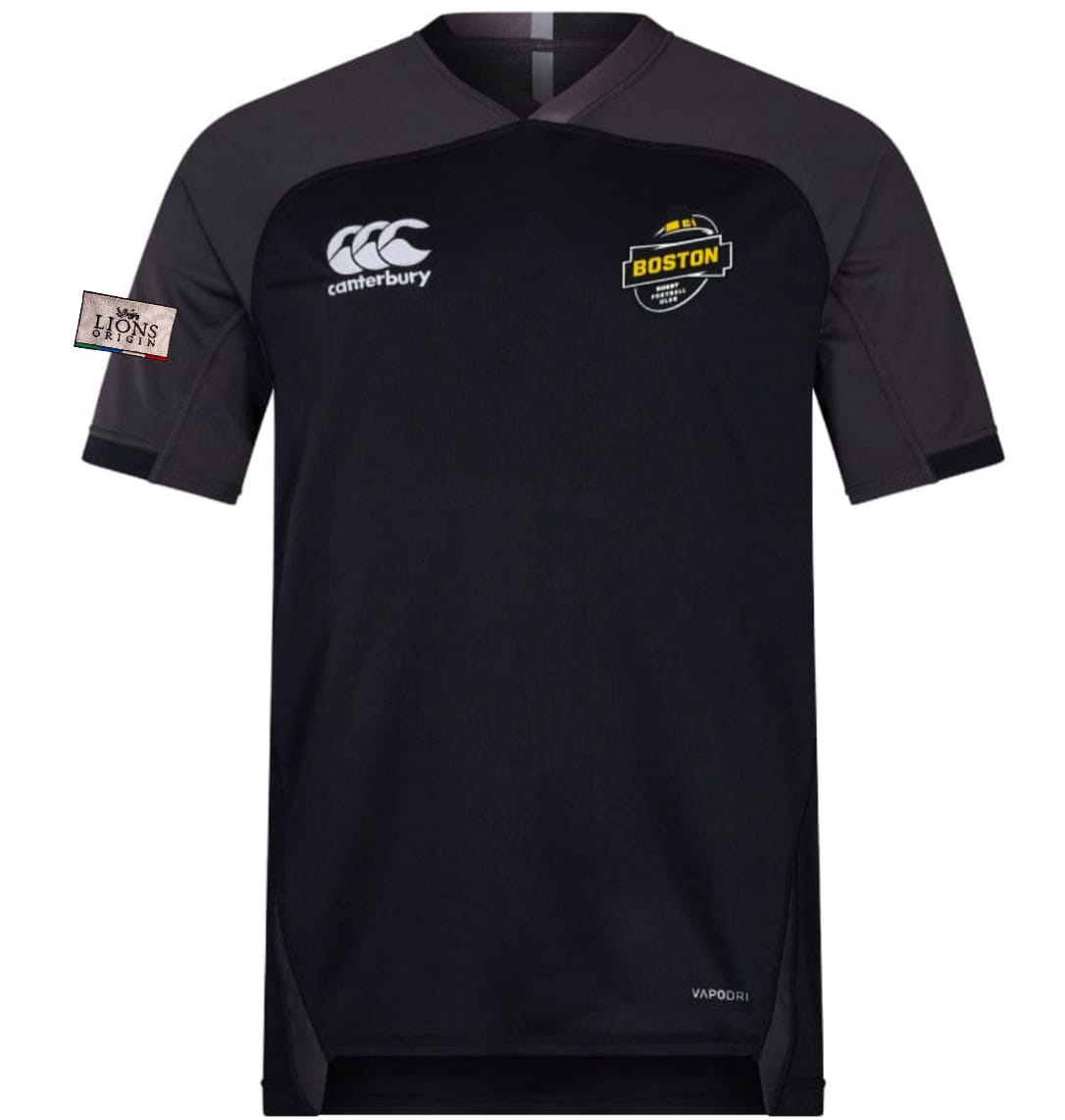 The EMB Canterbury Boston RFC Lions Origin Vapodri Evader Jersey is a black short-sleeve rugby top with a "Boston" chest badge, Canterbury logo, New England Free Jacks sleeve patch, and moisture-wicking tech for comfort.