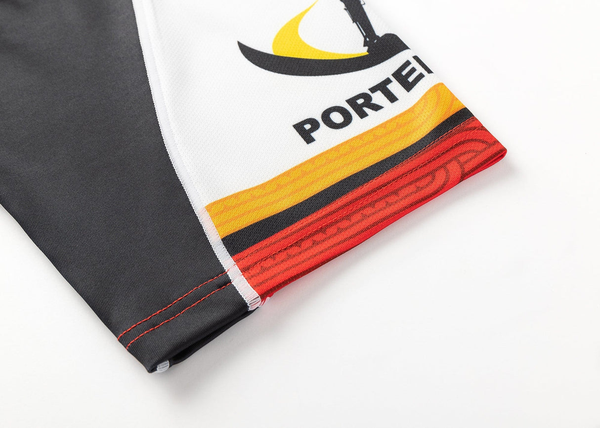 Close-up of the Gallagher Chiefs Super Rugby Replica Away Jersey 25/26 sleeve shows a black and yellow partial logo, "PORTEI," and a red-orange hem. The black and white sleeve mirrors Super Rugby's Gallagher Chiefs iconic style. Brand: Classic Sportswear.