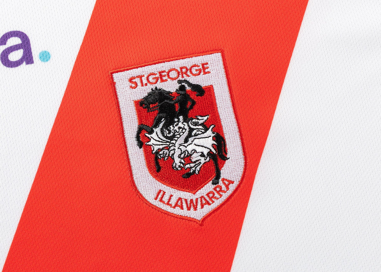 Close-up of the Dragons NRL 25/26 Replica Home Jersey logo by Classic Sportswear, showing a knight on a horse, embroidered on a white and red background.