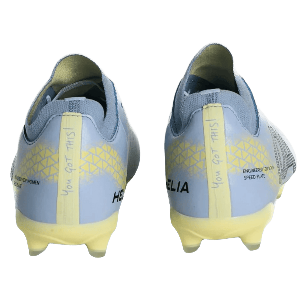 The IDA Sports IDA Helia Club FG - Light Blue women’s soccer cleats are shown from the back in light blue and yellow, each heel featuring the handwritten phrase "YOU GOT THIS!.