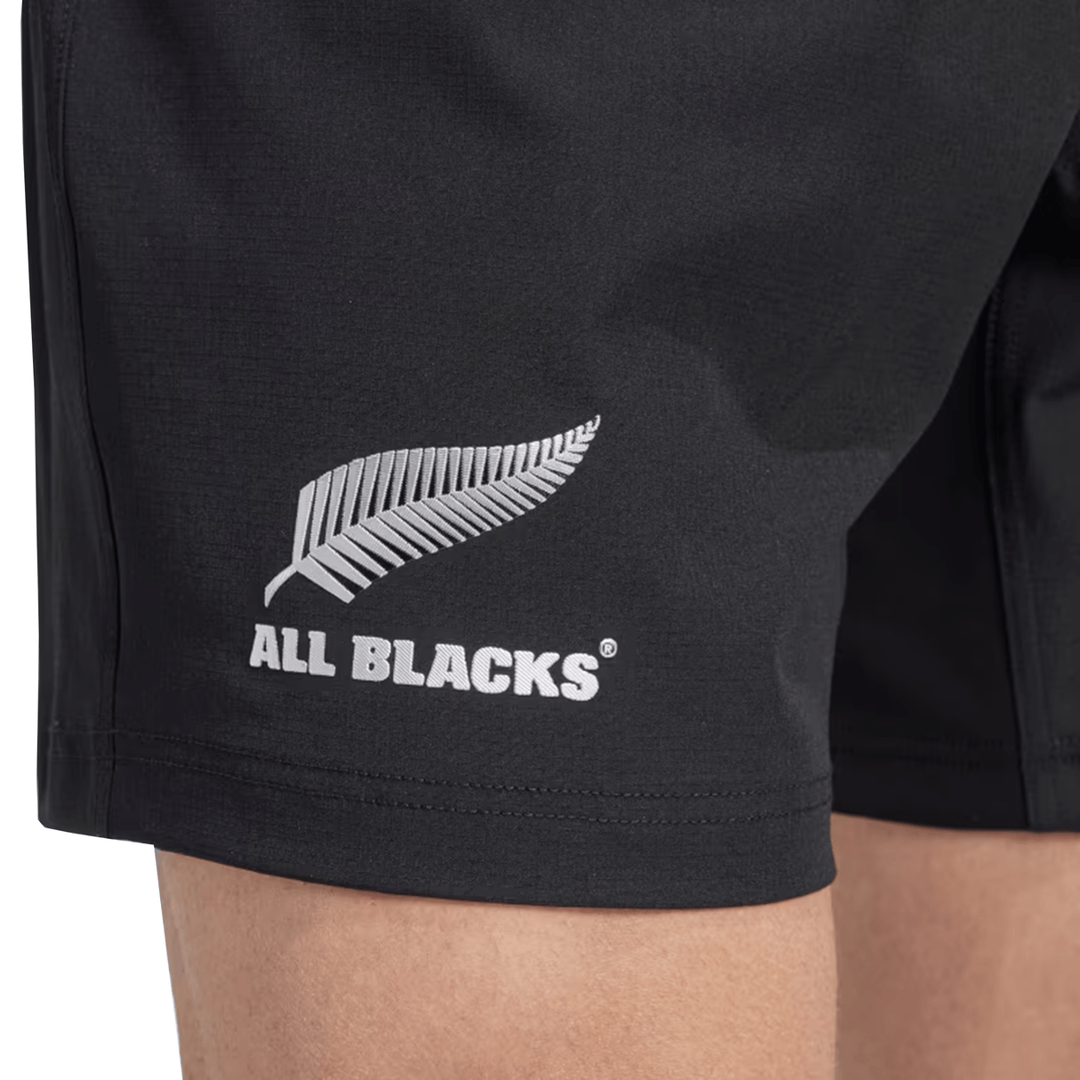 Close-up of the All Blacks 24/25 Home Shorts by adidas in black, showcasing the iconic silver fern. Made from recycled materials, these adidas rugby shorts expertly combine sustainability and style.