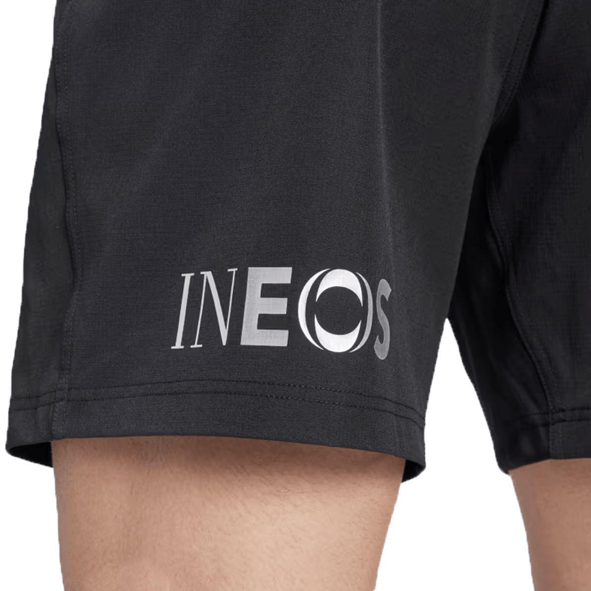 Close-up of a person wearing the adidas All Blacks 24/25 Home Shorts, featuring the INEOS logo on the side and made from recycled materials.