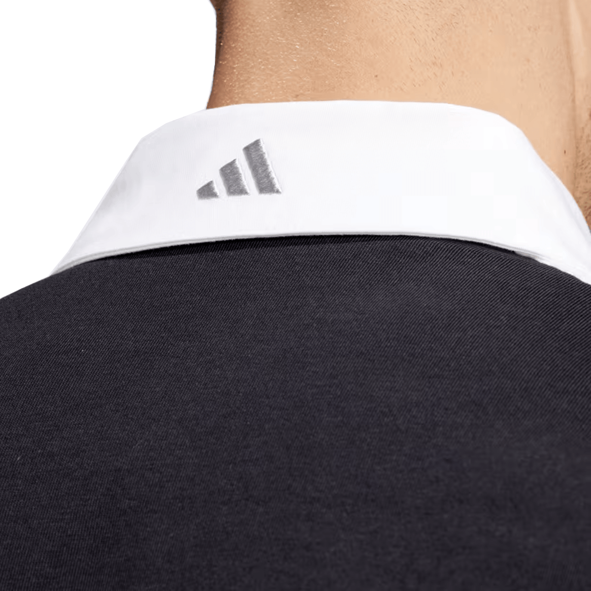 Close-up of a person in the All Blacks 24/25 Culture Jersey by adidas, showcasing its black design with a white collar and the iconic three-striped logo on the back.