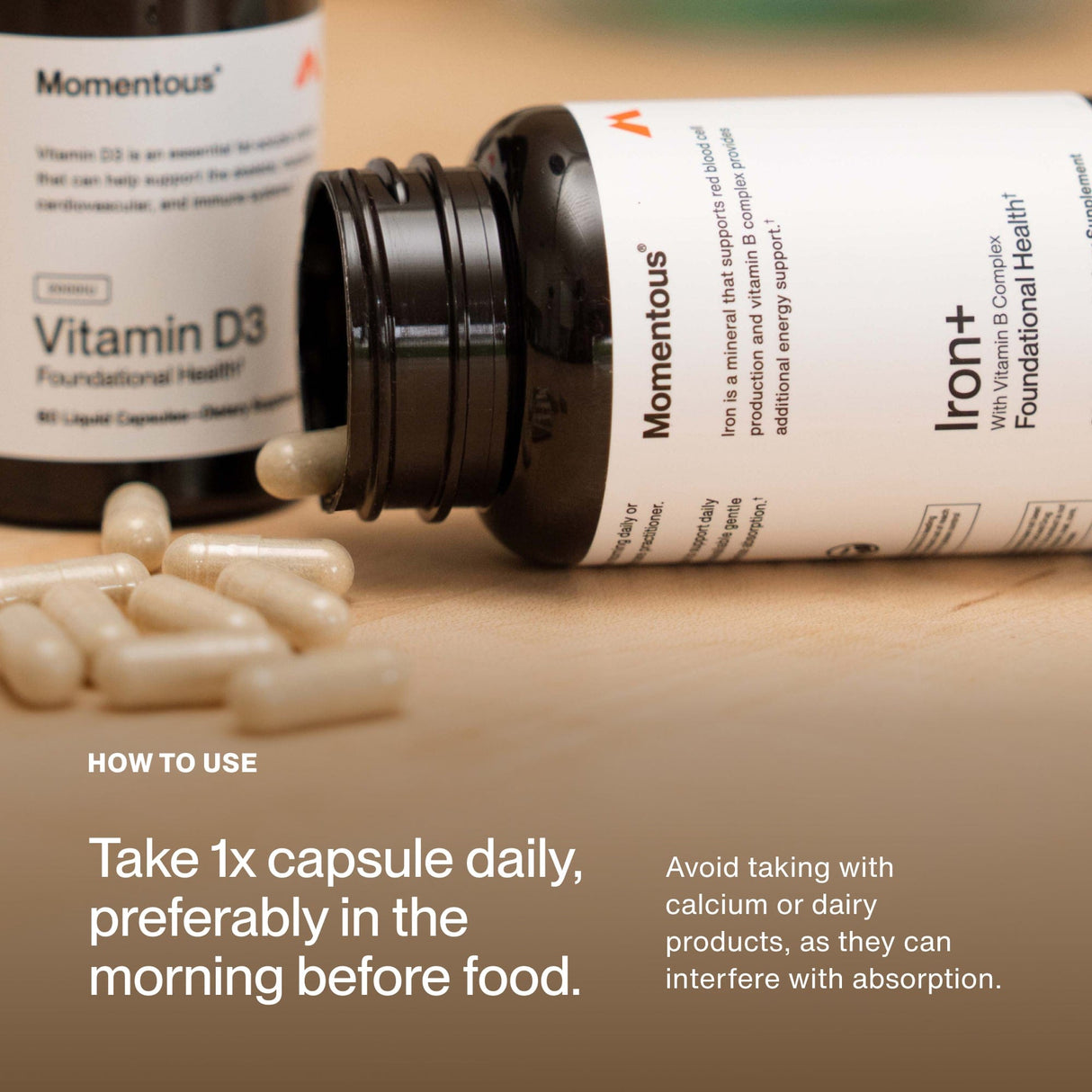 A bottle of Momentous Iron+ from Momentous lies on a table with scattered capsules. Instructions recommend taking one capsule daily in the morning before food, as an iron supplement for energy support, avoiding calcium or dairy.