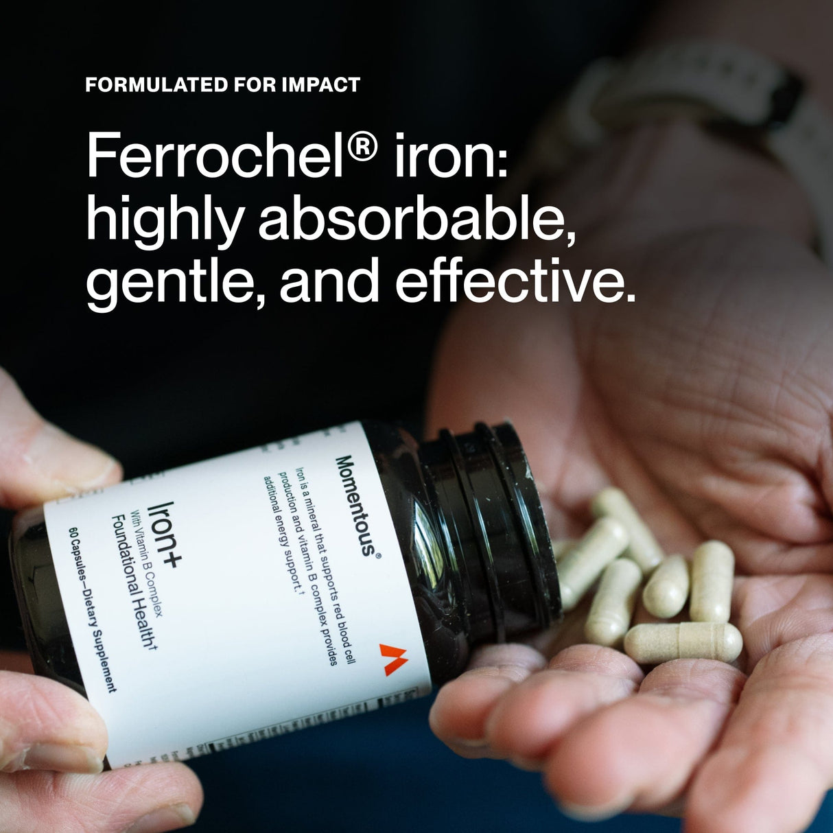 A person holds an open bottle of Momentous Iron+ by Momentous in one hand and several capsules in the other, displaying the label and pills—ideal for energy support and daily wellness.
