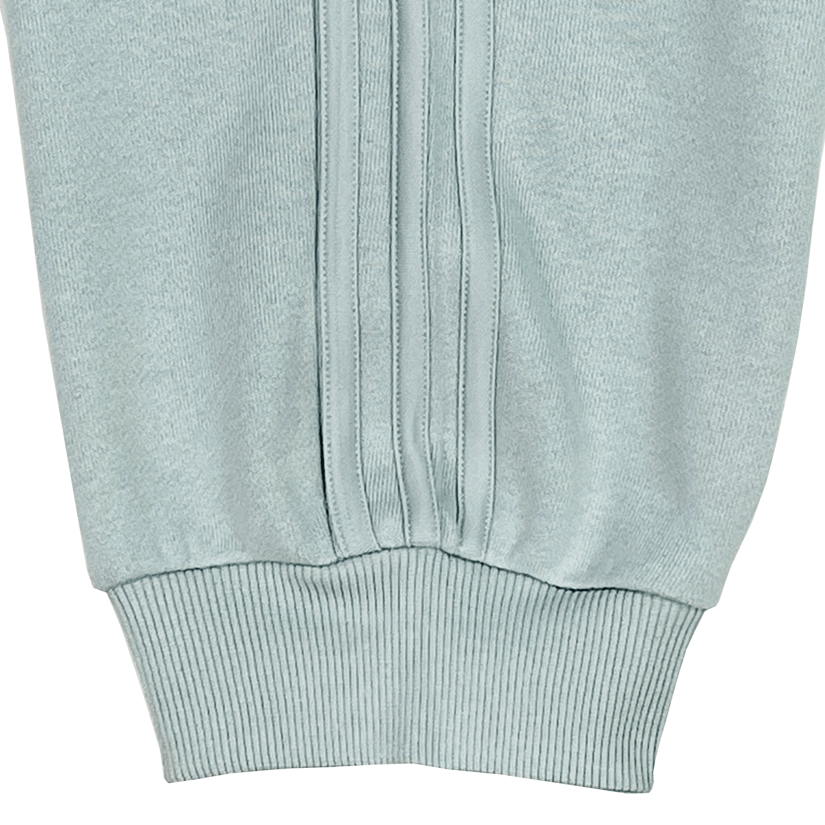 Close-up of a ribbed-textured light blue sleeve cuff with vertical stitching, echoing the precision found in adidas's Women's All Blacks 24/25 Fan Cuffed Pant.