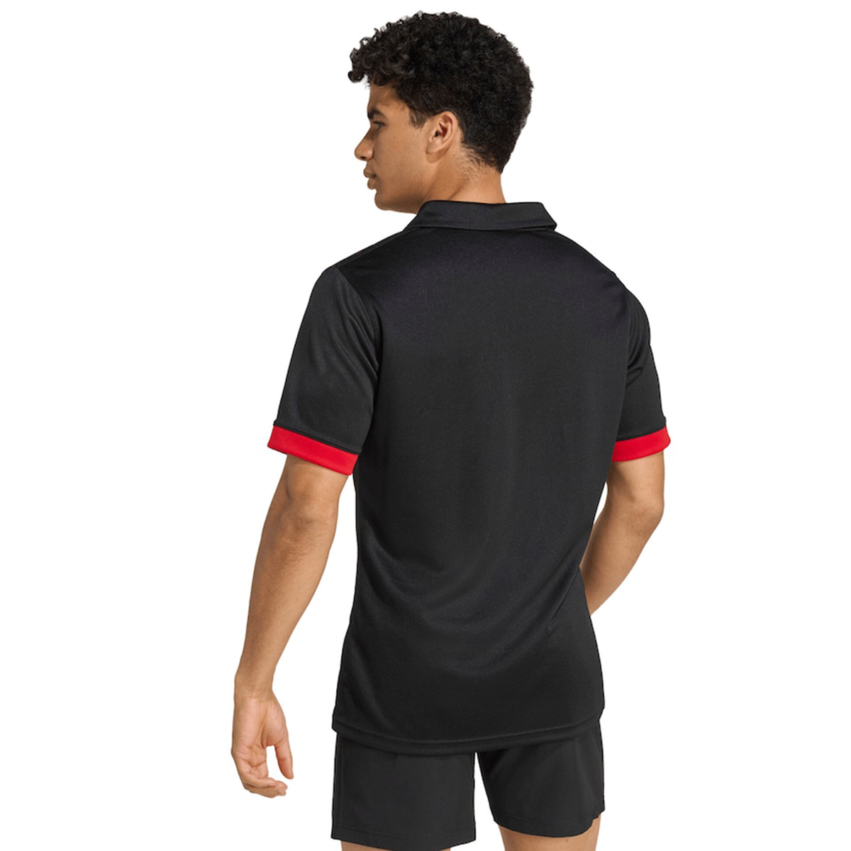 A person is shown from the back wearing the adidas Maori All Blacks 25/26 Replica Home Jersey with red sleeve cuffs and black shorts, standing against a plain white background.
