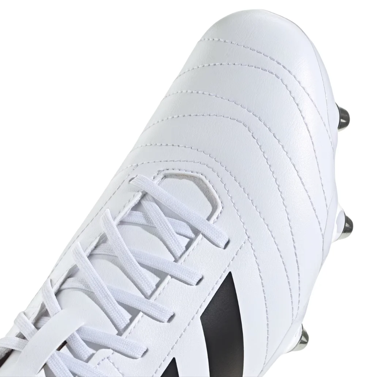 Close-up of the adidas Kakari SG rugby boot in White/Core Black/Silver Metallic, featuring white laces, visible stitching, and a partial black stripe on the side, all emphasizing its soft ground design.