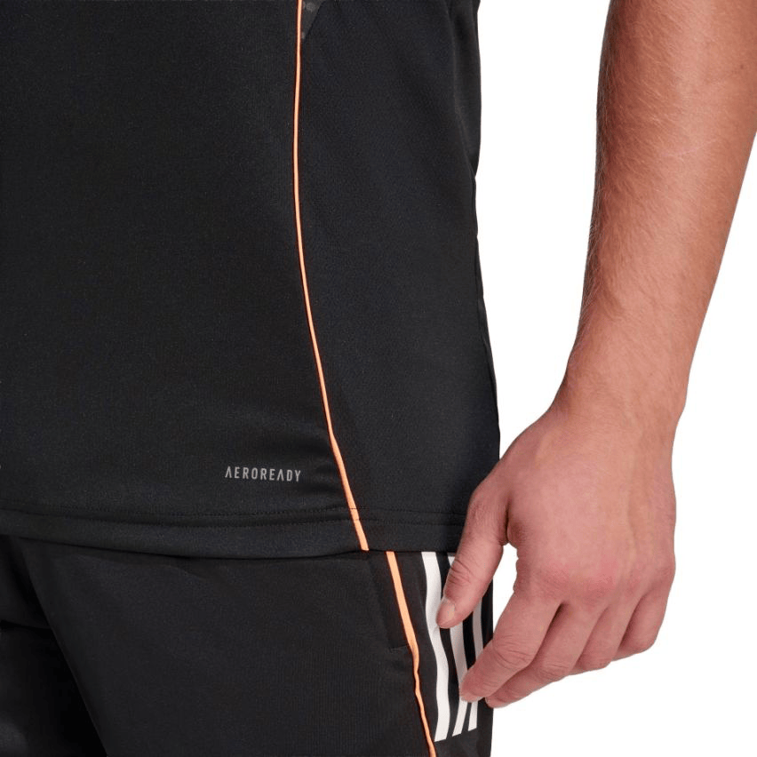 Close-up of a person wearing the adidas All Blacks 26/27 Marvel Performance Training Singlet in black, featuring "AEROREADY" text, paired with black adidas shorts with white stripes, highlighting the lower torso and right hand.