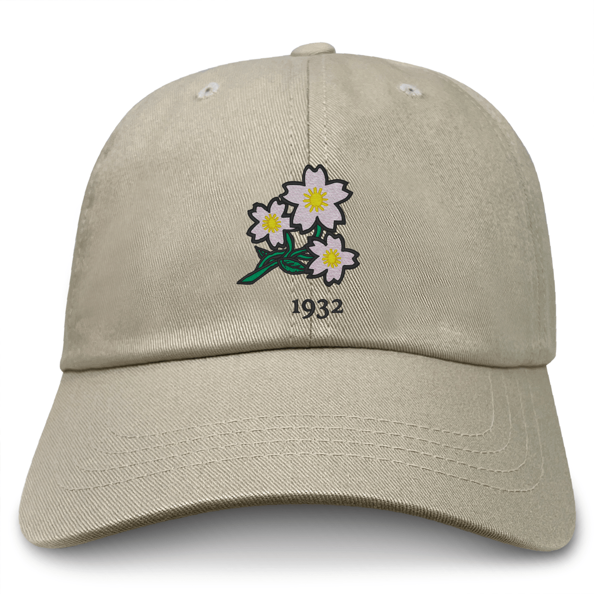The Nations of Rugby Japan Vintage Dad Cap by EMB S&S Activewear comes in beige and showcases an embroidered design of three white flowers with yellow centers, green leaves, and the number "1932" above them.