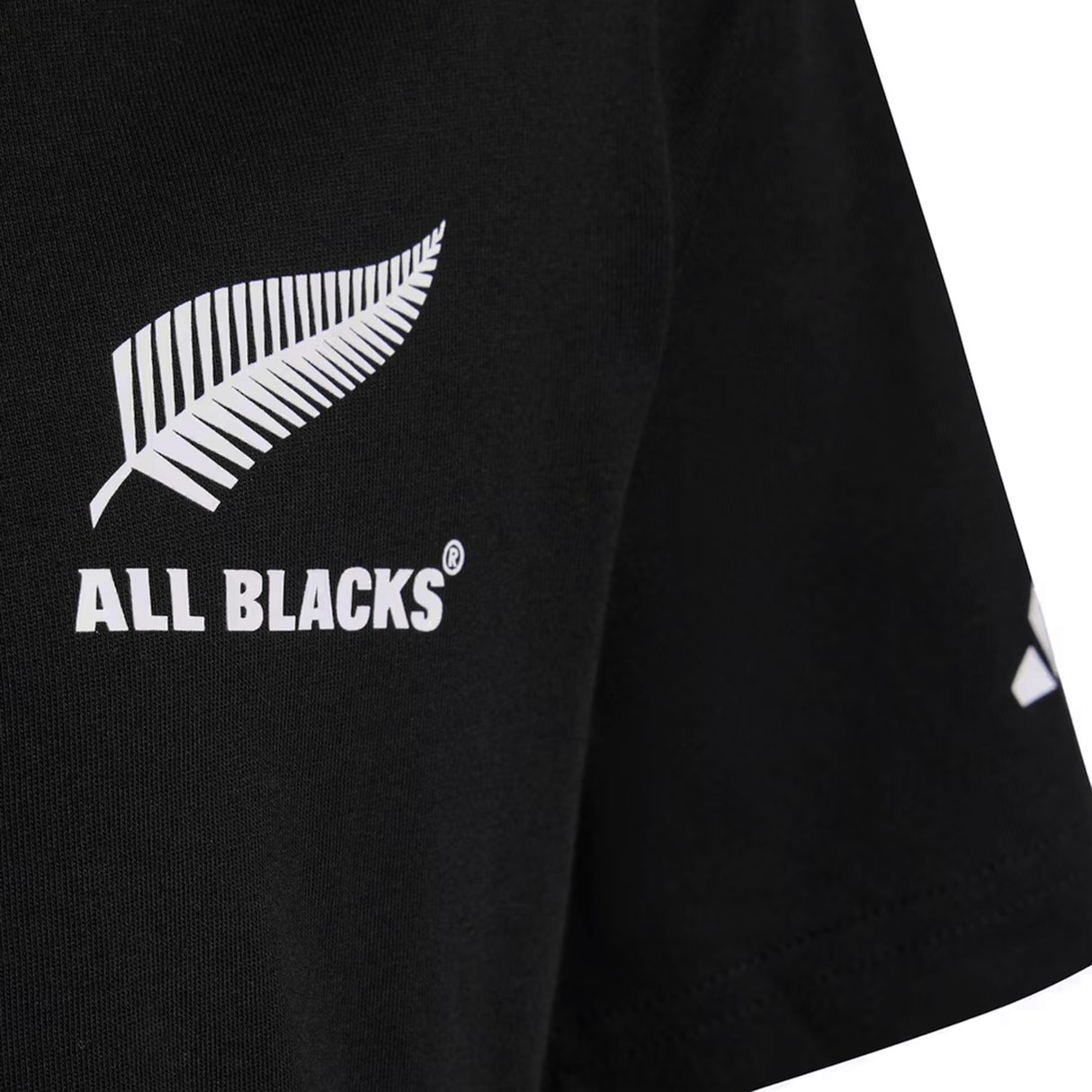Close-up of the All Blacks 26/27 Marvel Leisure Tee by adidas, a black shirt with a white silver fern and "ALL BLACKS®" on the chest, celebrating New Zealand rugby heritage.
