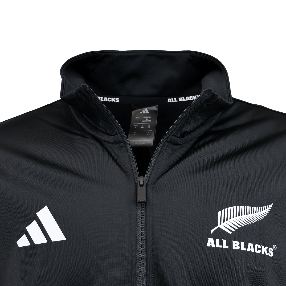 Close-up of a black adidas All Blacks 26/27 Marvel Track Top, featuring the adidas logo and All Blacks silver fern emblem on the chest, with a tag inside the collar—part of the exclusive Marvel Track Top collection.